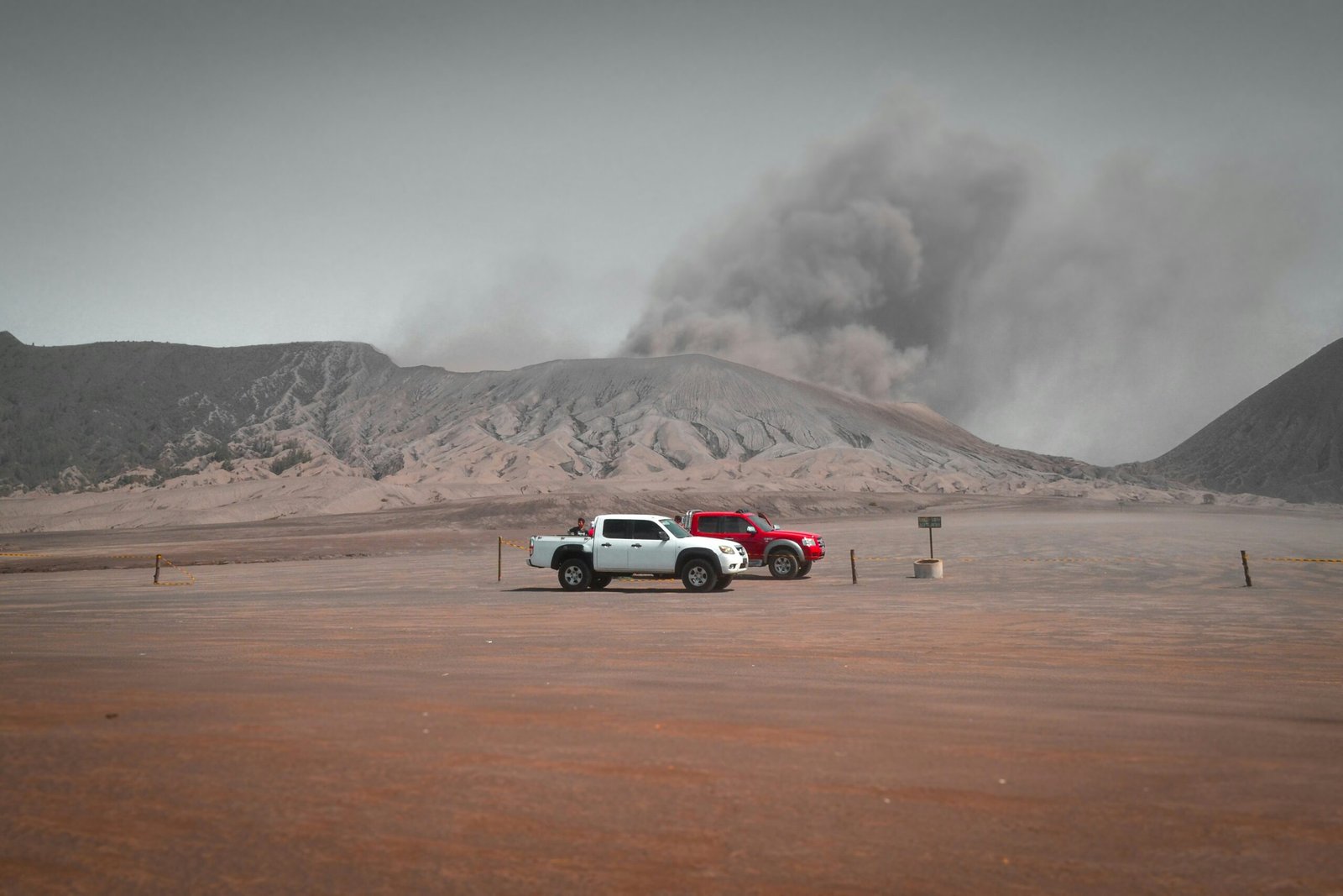 white suv on brown sand under white clouds during daytime